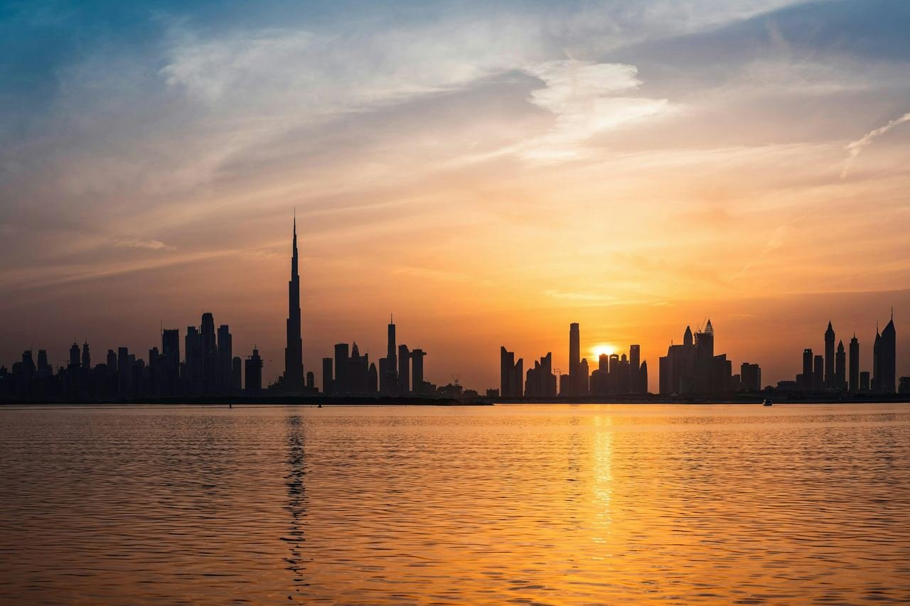 Sun rising over the Dubai skyline across the water